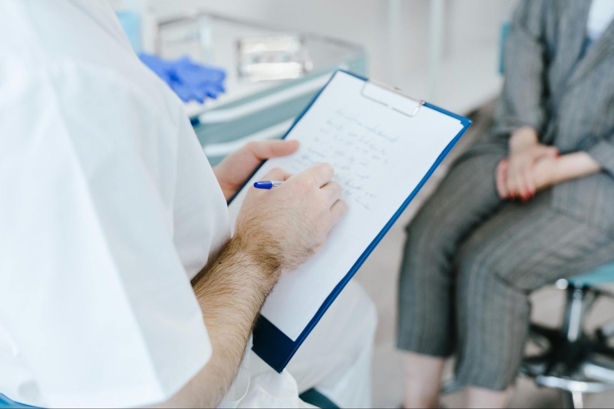 Healthcare provider reviewing notes during a preventive care appointment with a patient
